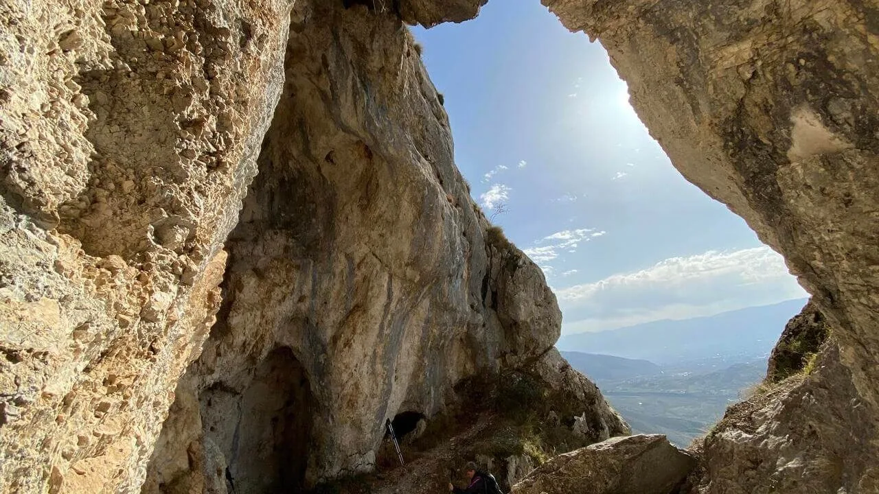 Escursionisti del CAI ammirano il panorama sulla Conca del Fucino dalla Grotta di San Benedetto, Parco Sirente-Velino.