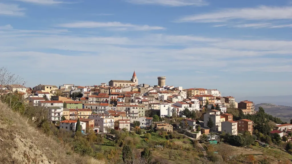Vista panoramica del borgo di Colletorto con torre e chiesa sotto cielo azzurro
