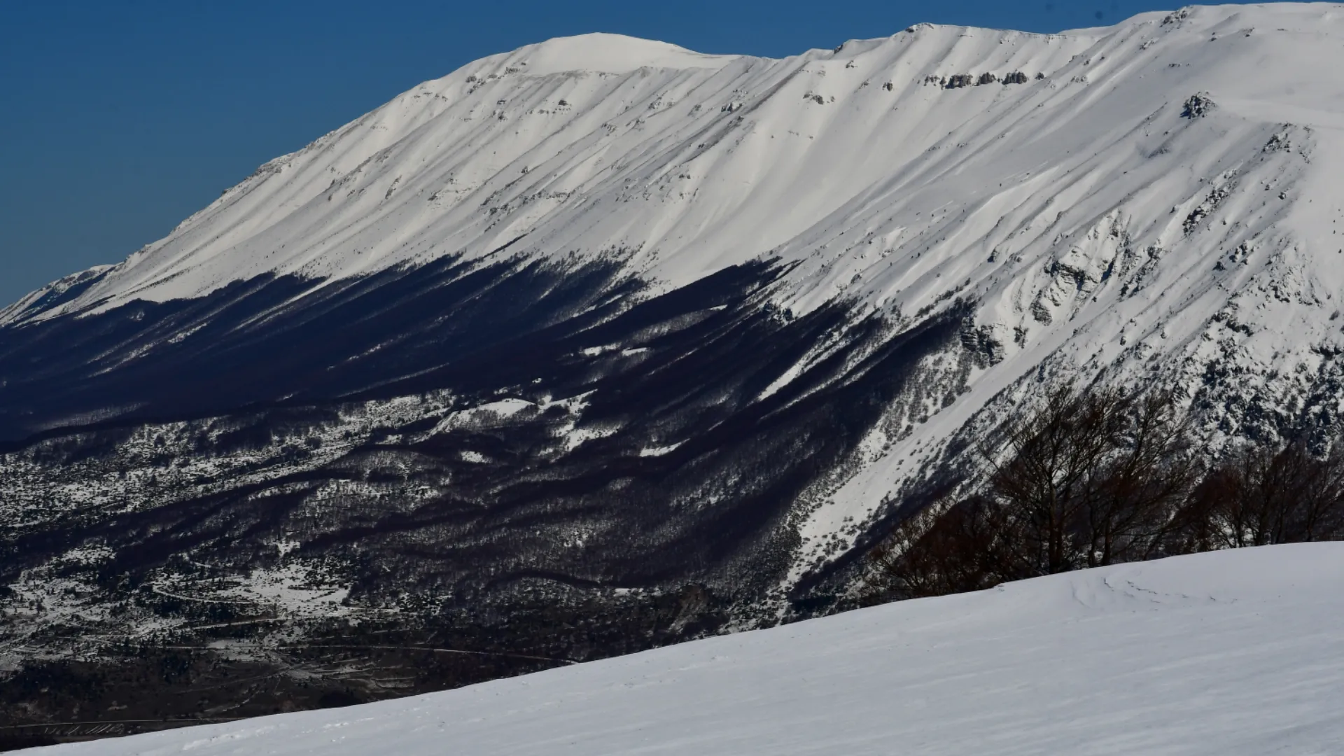 Panoramica invernale del massiccio del Monte Amaro coperto di neve, visto dalla prospettiva del Monte Pizzalto.